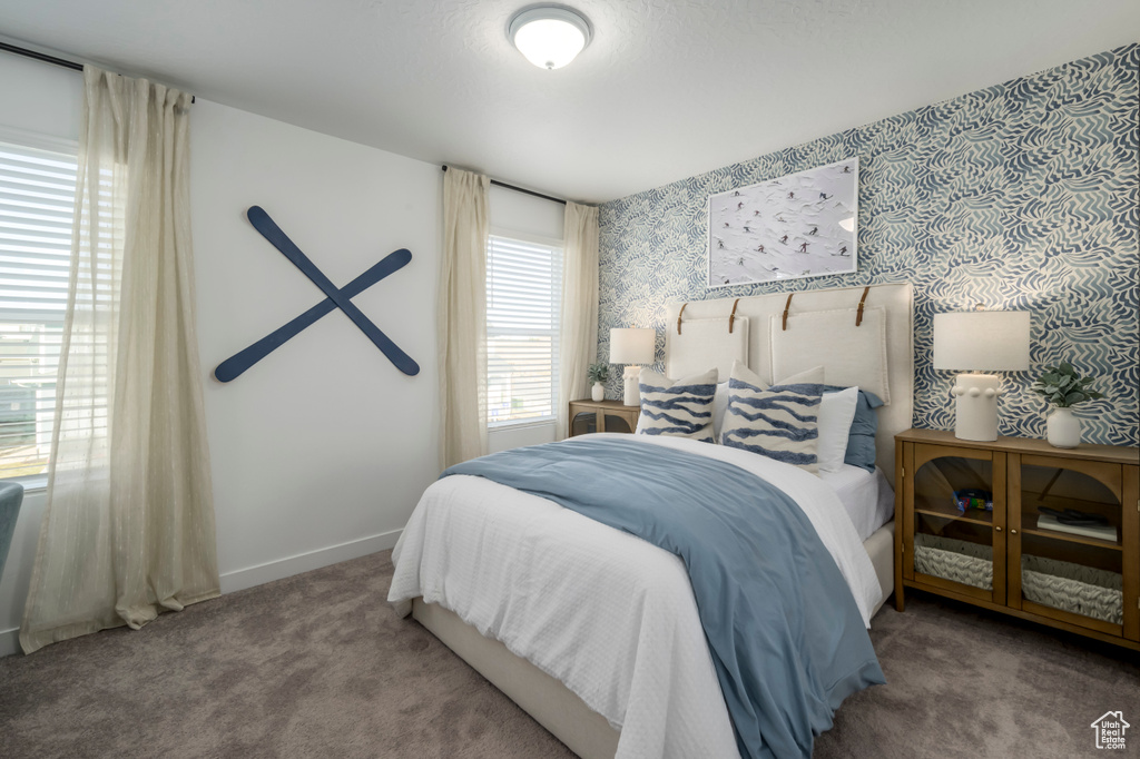 Bedroom featuring wallpapered walls, carpet floors, and baseboards