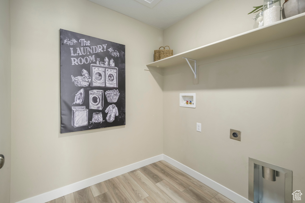 Laundry room with hookup for a washing machine, baseboards, wood finished floors, laundry area, and hookup for an electric dryer