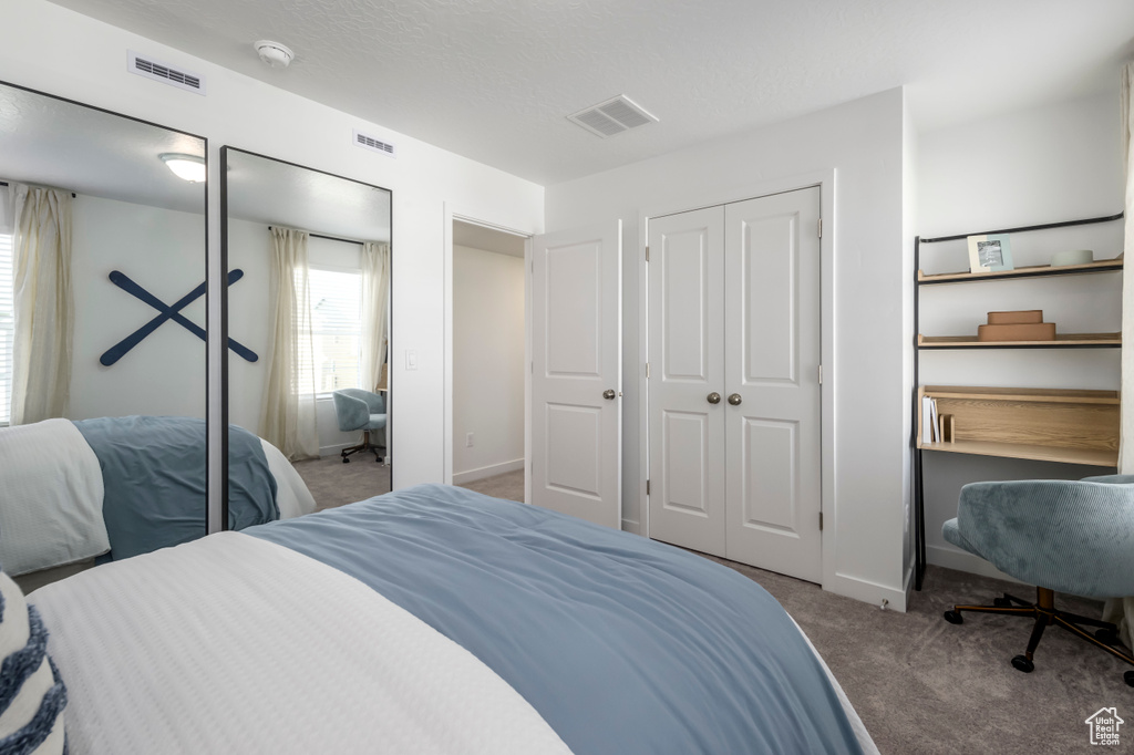 Carpeted bedroom with baseboards and visible vents