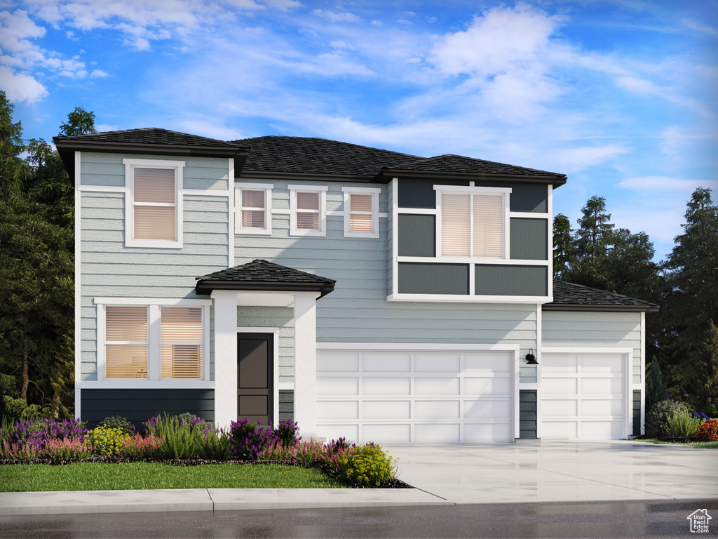 View of front of home featuring concrete driveway and an attached garage