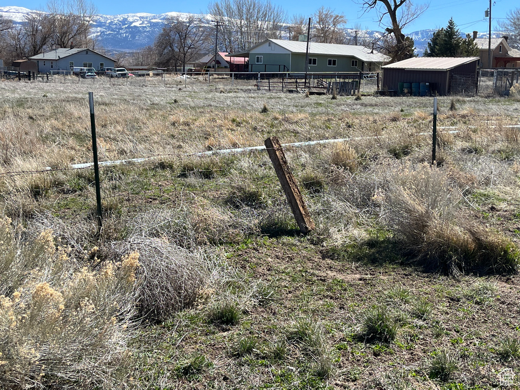 View of yard with fence and a rural view