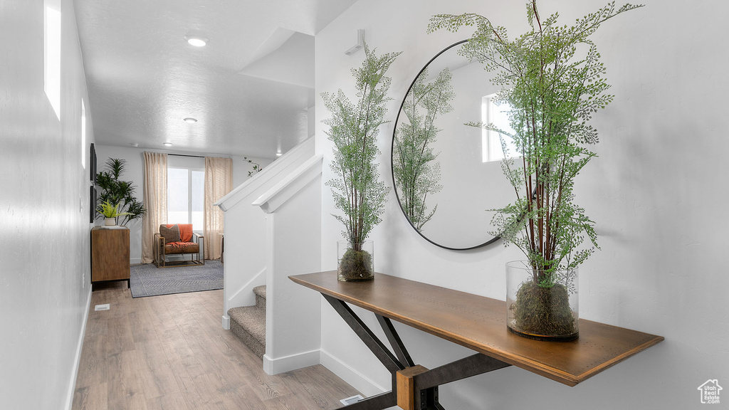 Entryway with baseboards, stairs, and wood finished floors