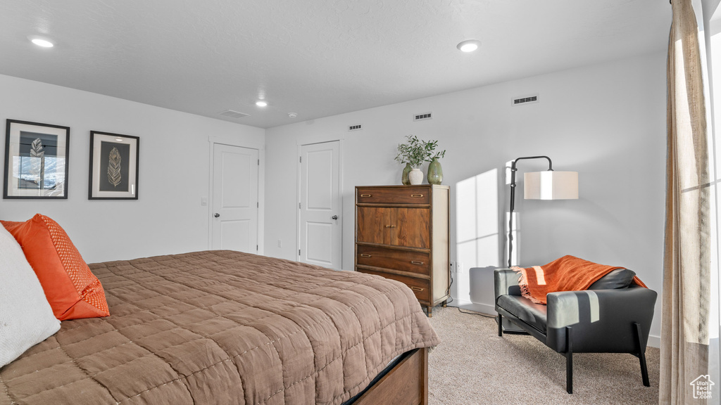 Bedroom featuring light carpet, visible vents, and recessed lighting