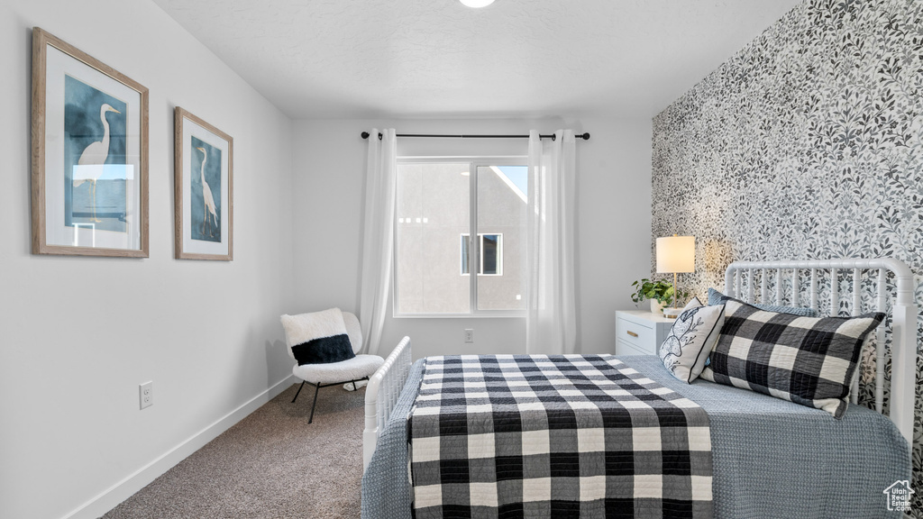 Carpeted bedroom with baseboards and an accent wall