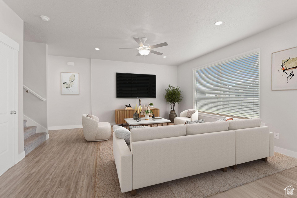 Living room featuring ceiling fan, stairs, recessed lighting, baseboards, and wood finished floors