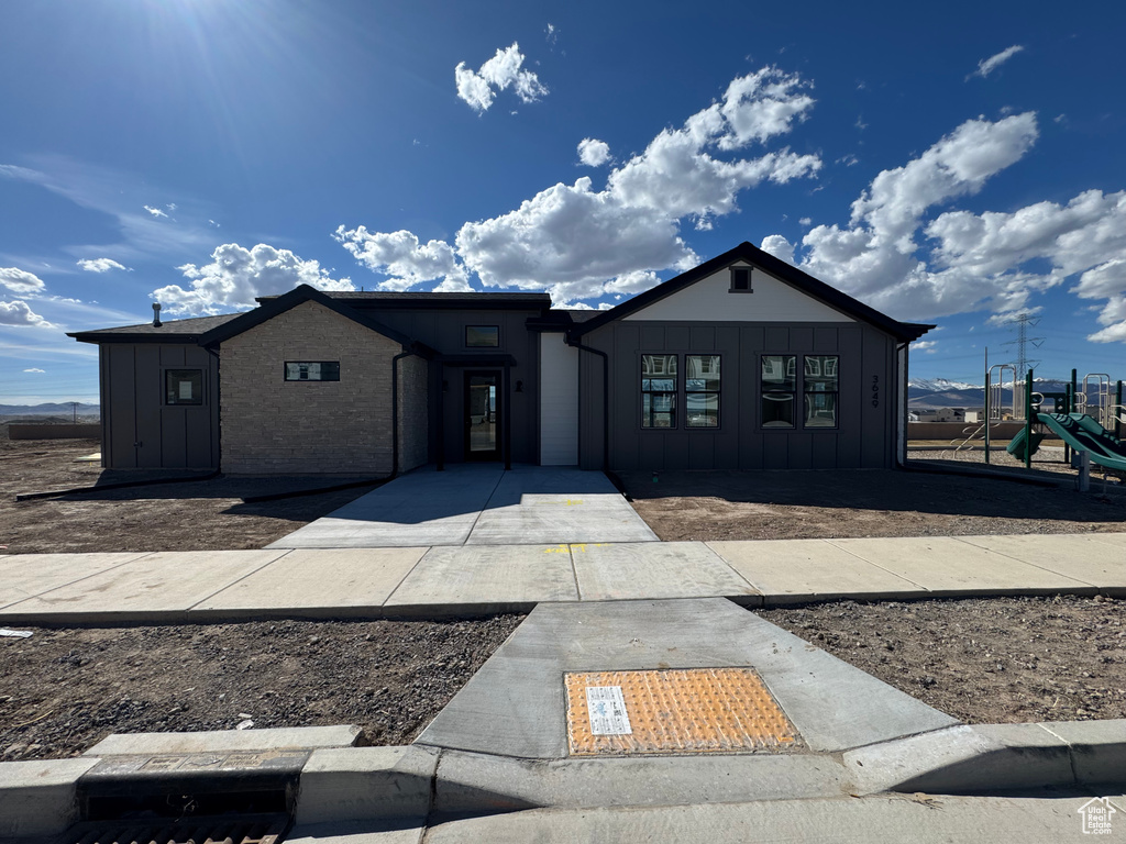 View of front facade featuring board and batten siding and a playground