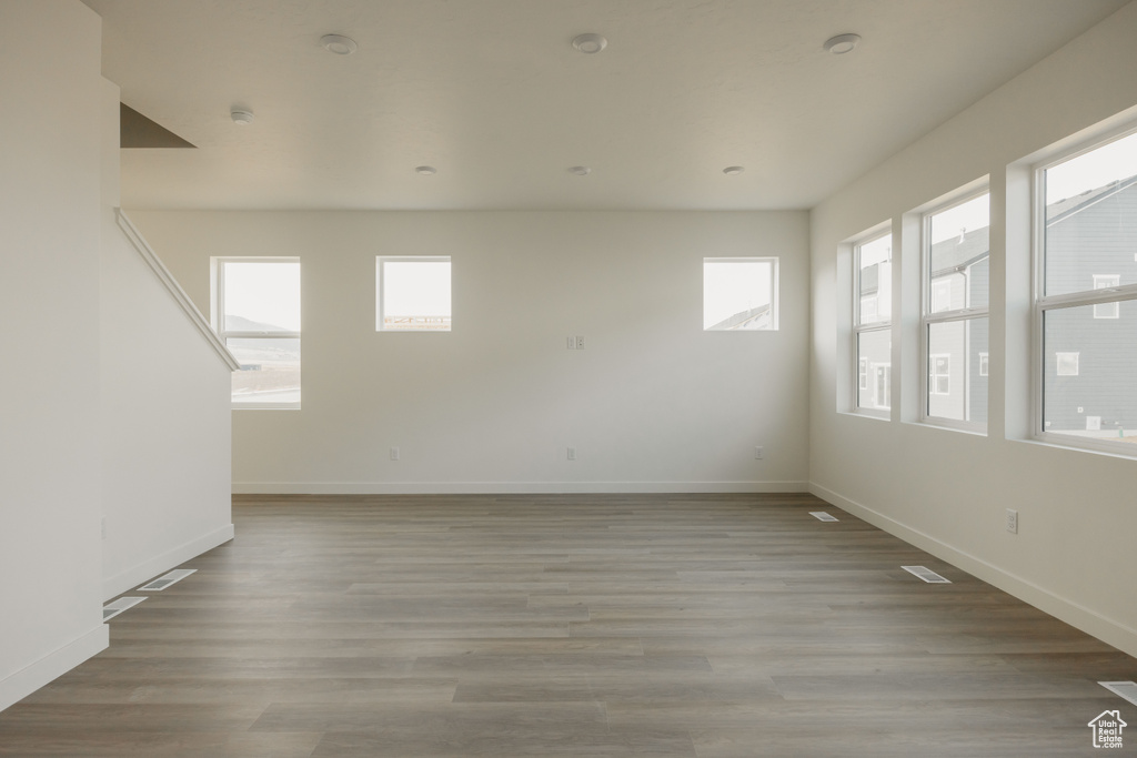 Unfurnished room with visible vents, baseboards, and wood finished floors
