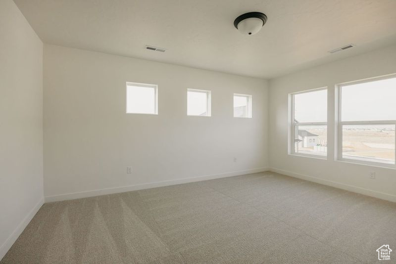 Unfurnished room with light colored carpet, visible vents, and baseboards