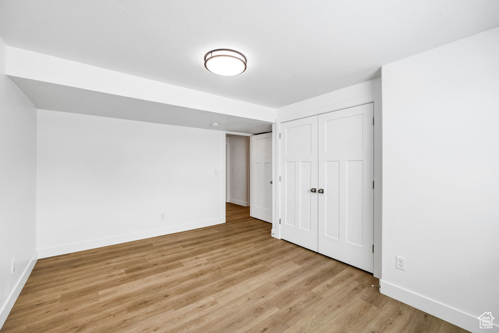 Unfurnished bedroom with a closet, baseboards, and light wood finished floors