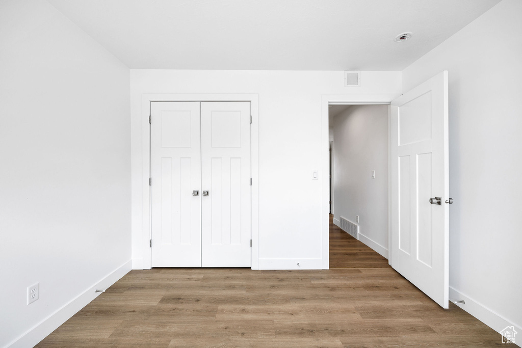 Unfurnished bedroom with baseboards, visible vents, and light wood-type flooring