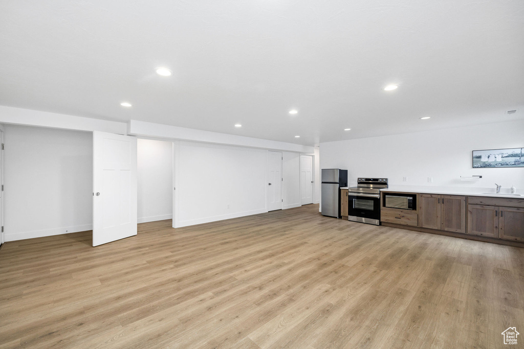 Kitchen with light wood-type flooring, recessed lighting, a sink, and stainless steel appliances