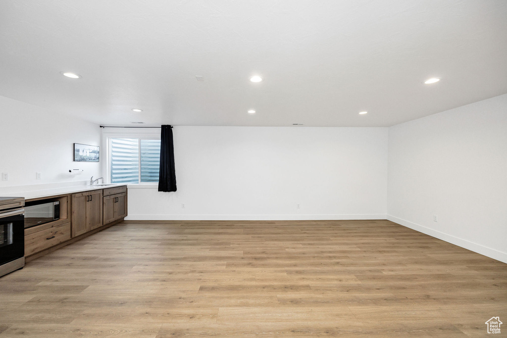 Interior space featuring baseboards, stainless steel appliances, recessed lighting, a sink, and light wood-type flooring