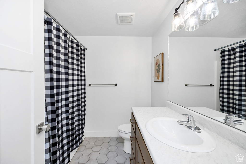 Full bath with visible vents, a shower with shower curtain, toilet, vanity, and tile patterned flooring