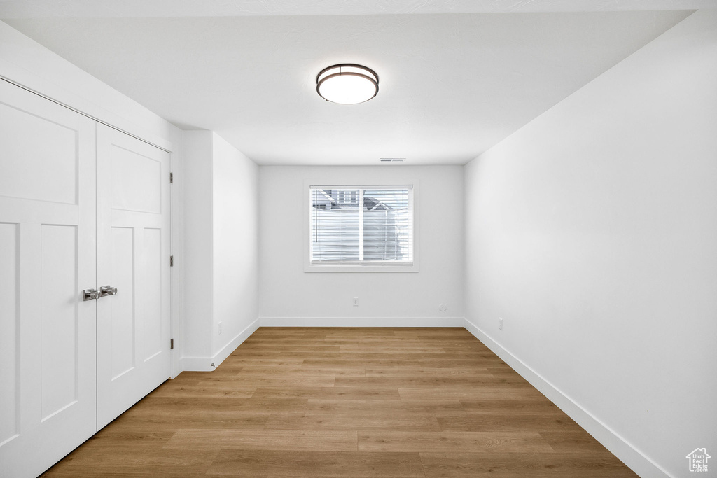 Empty room with baseboards, visible vents, and light wood-style flooring