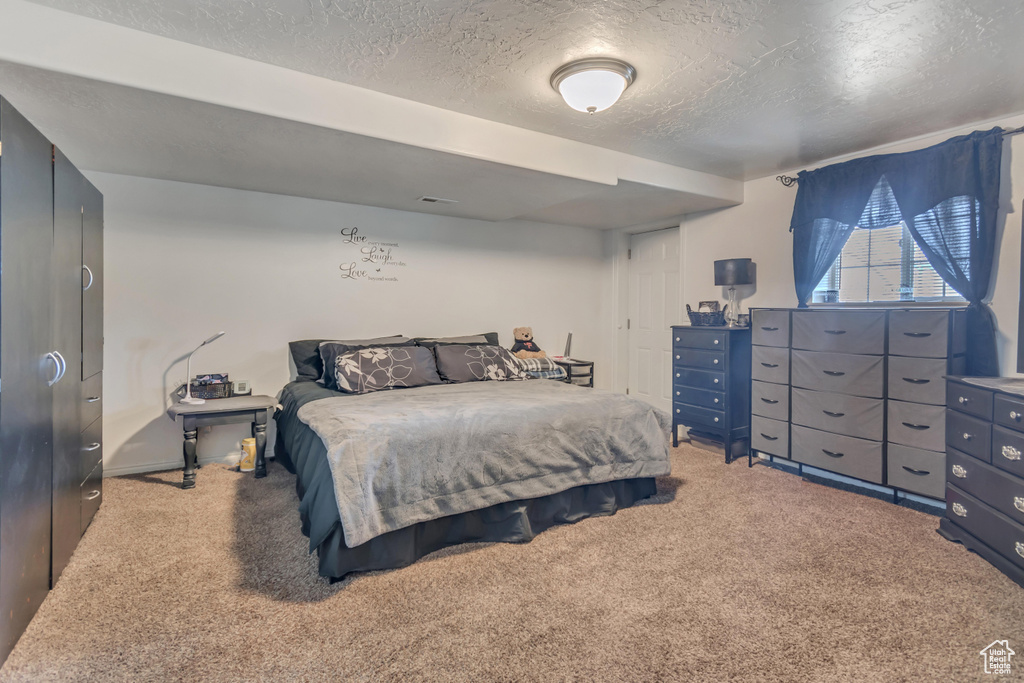 Carpeted bedroom with a textured ceiling