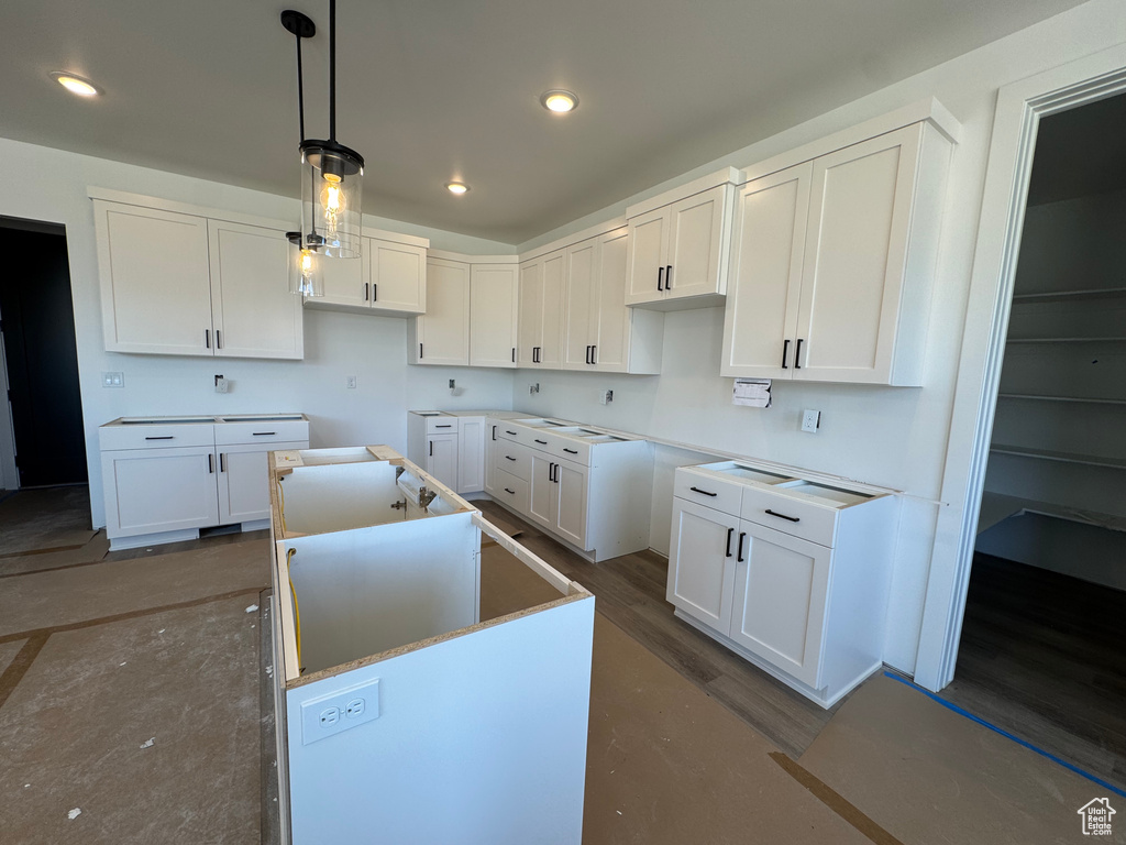 Kitchen featuring a center island, white cabinetry, decorative light fixtures, and recessed lighting