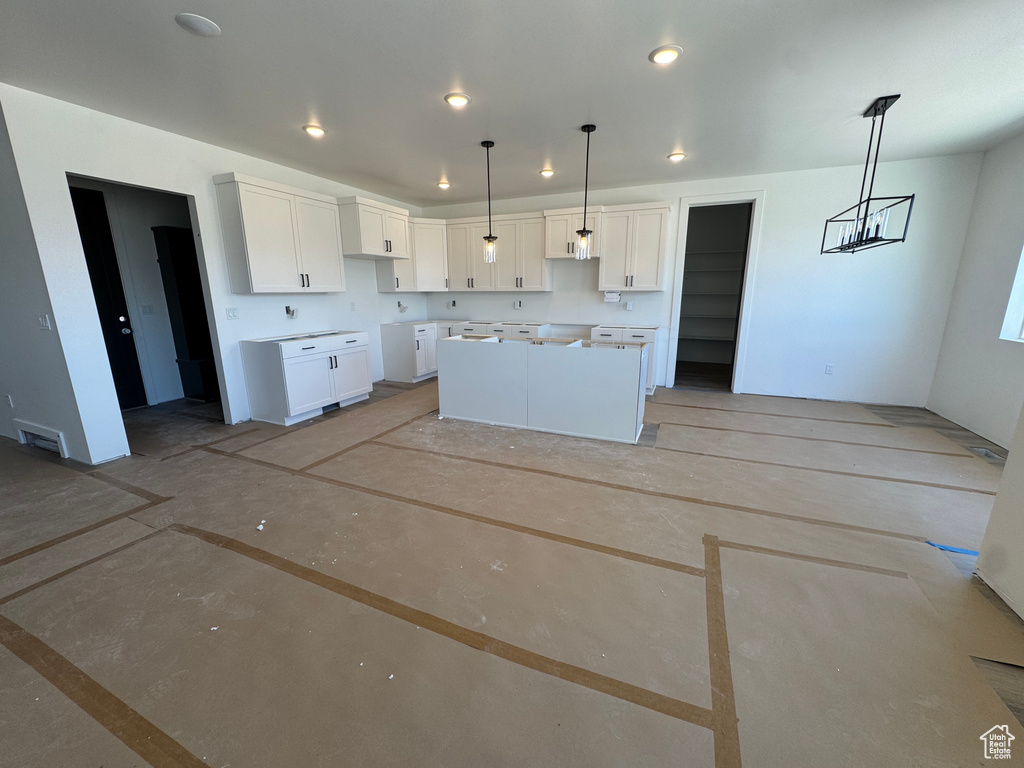 Kitchen featuring a kitchen island, hanging light fixtures, visible vents, white cabinets, and recessed lighting