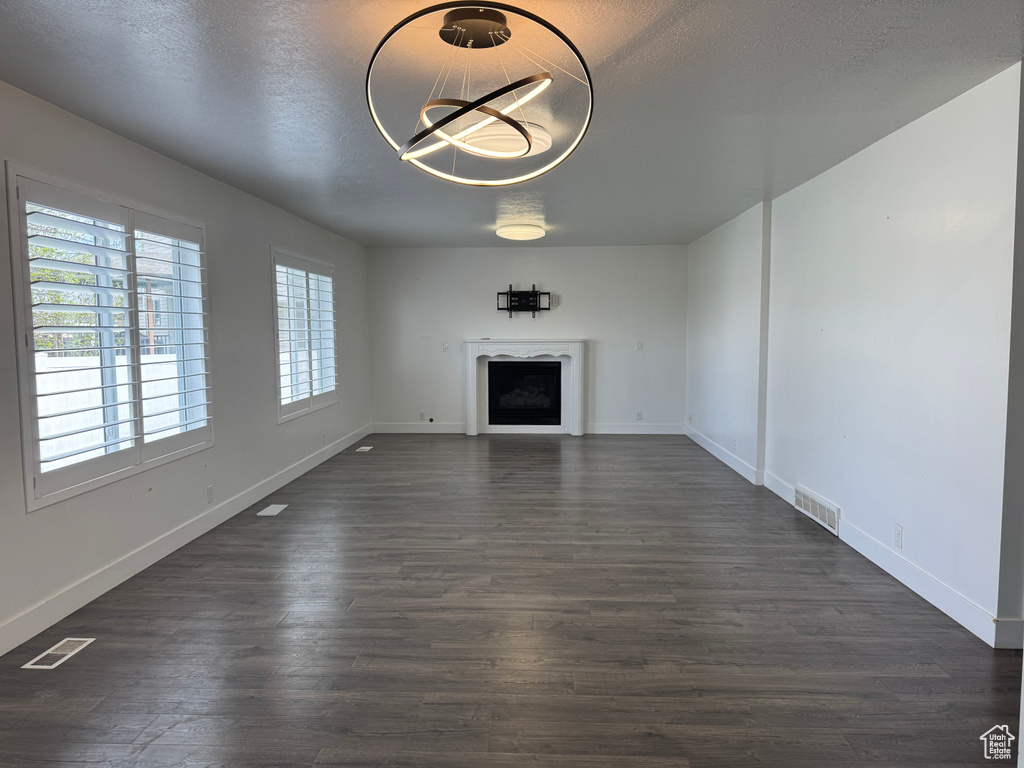 Unfurnished living room featuring baseboards, a fireplace, and visible vents