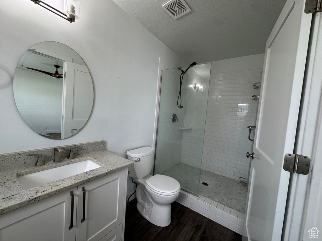 Bathroom with vanity, toilet, a shower stall, visible vents, and wood finished floors