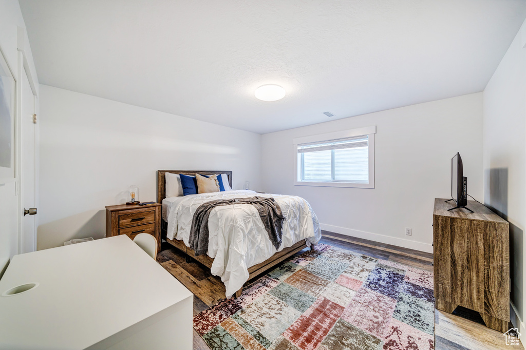 Bedroom featuring baseboards, visible vents, and wood finished floors