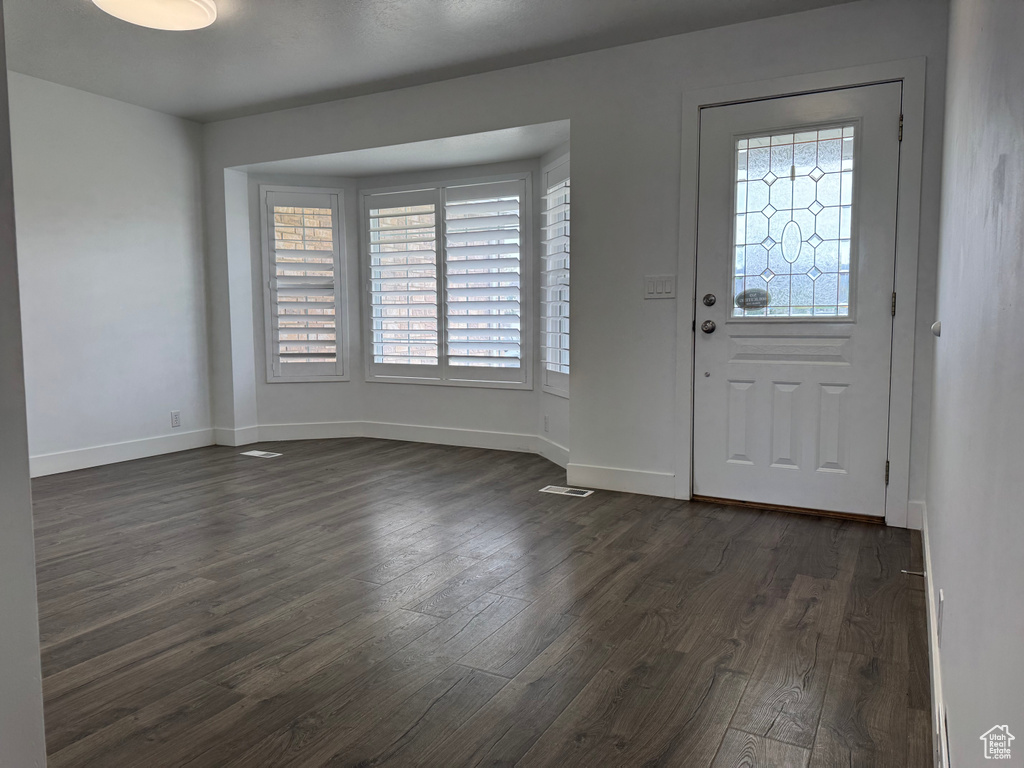Entrance foyer featuring baseboards and dark wood-style floors