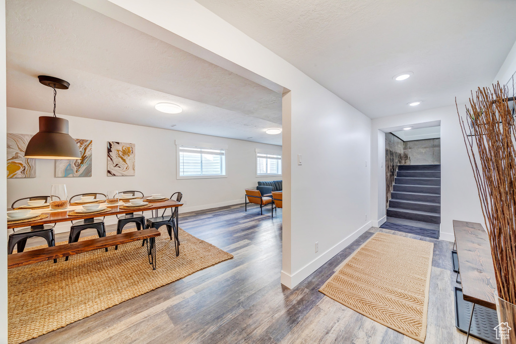 Dining area featuring baseboards, stairs, wood finished floors, and recessed lighting