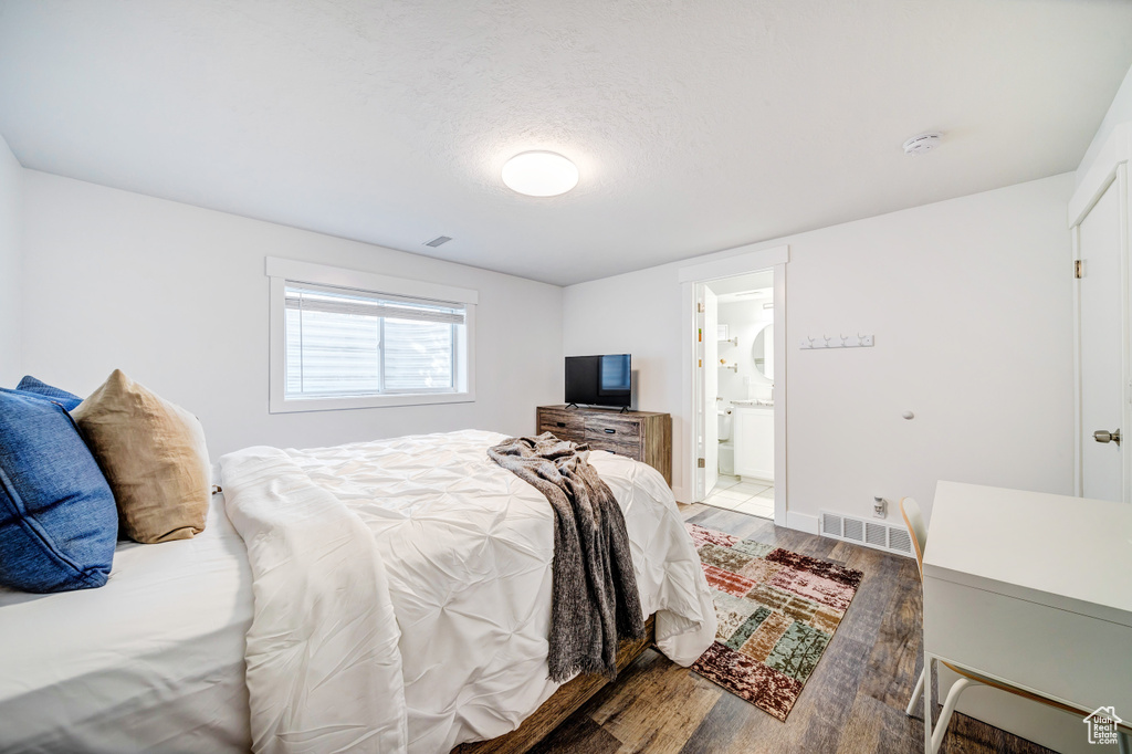 Bedroom with wood finished floors, a textured ceiling, baseboards, and visible vents