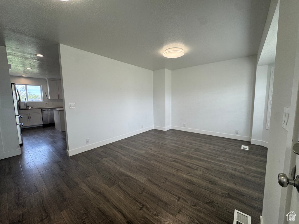 Empty room featuring recessed lighting, visible vents, baseboards, and dark wood-style floors