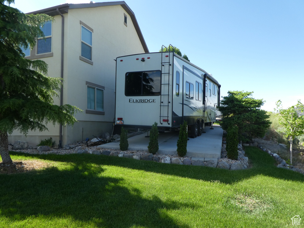 View of side of home featuring a yard and stucco siding