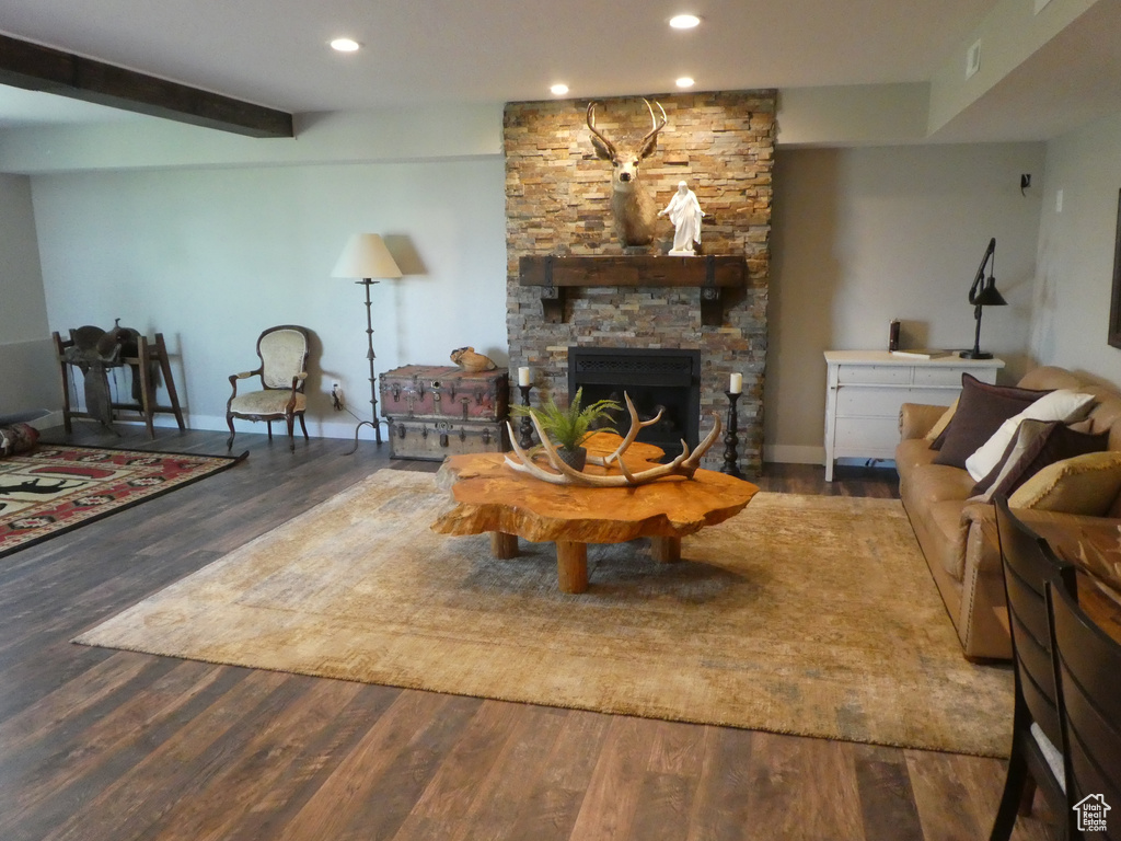 Living room featuring wood finished floors, recessed lighting, a fireplace, baseboards, and beam ceiling