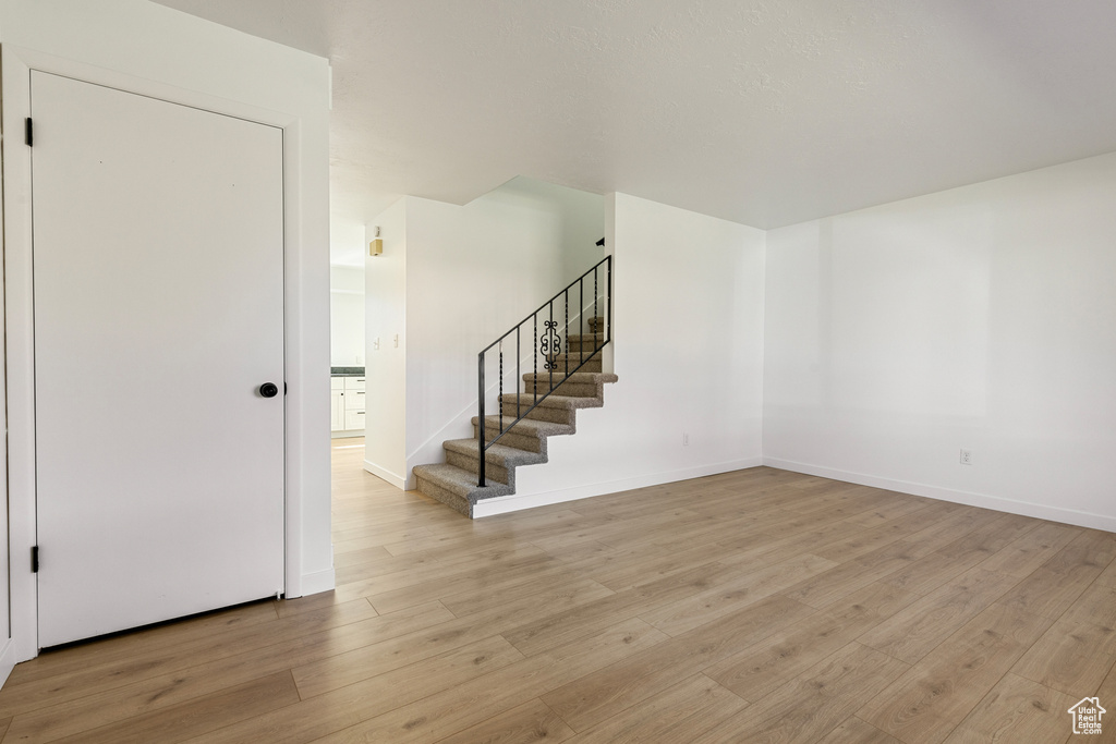 Interior space featuring light wood finished floors, baseboards, and stairway