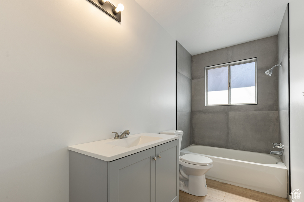 Full bath featuring vanity, wood finished floors, toilet, and bathing tub / shower combination