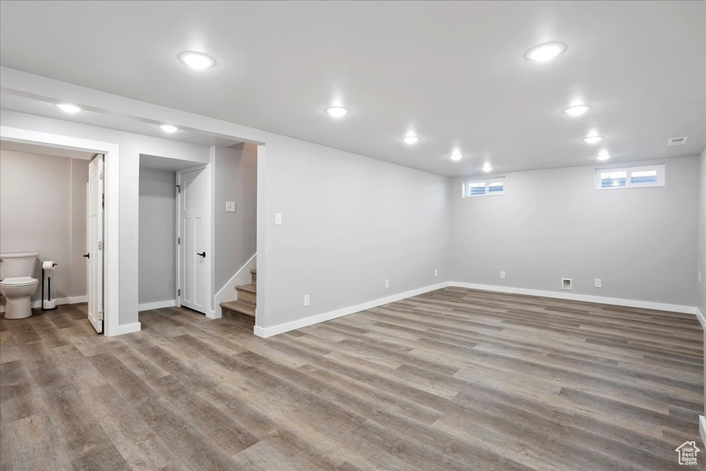 Basement featuring baseboards, stairs, and wood finished floors