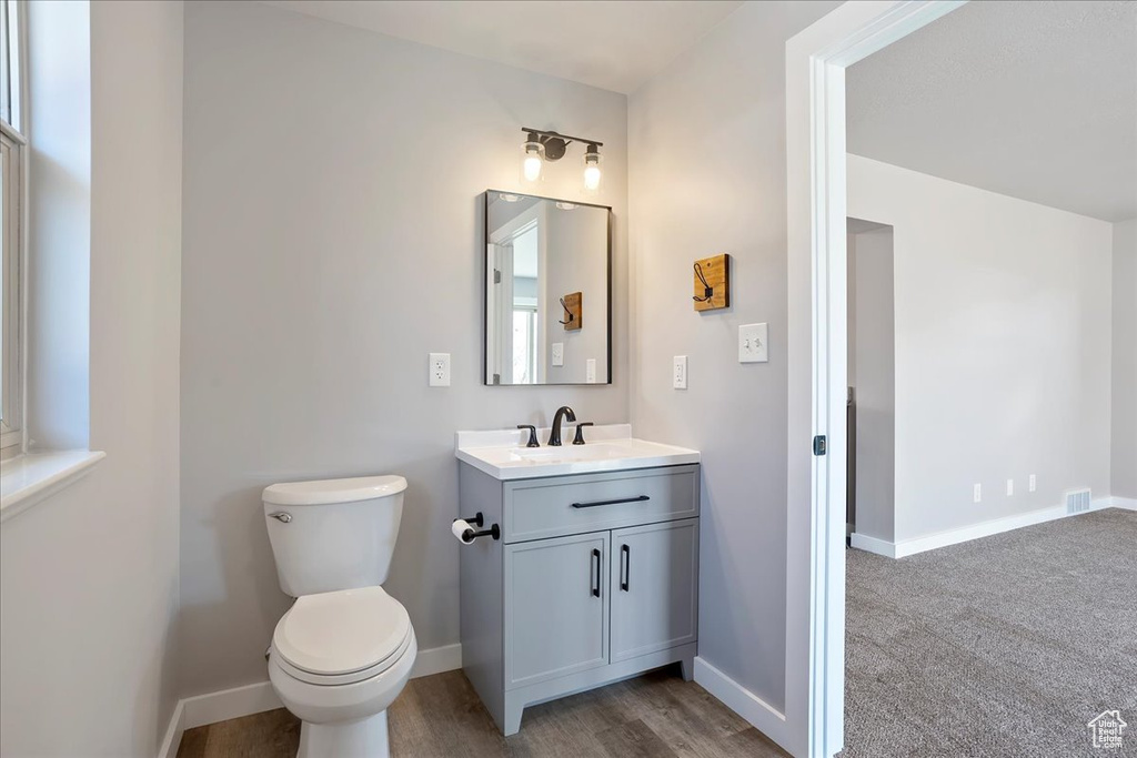 Bathroom with baseboards, toilet, and vanity