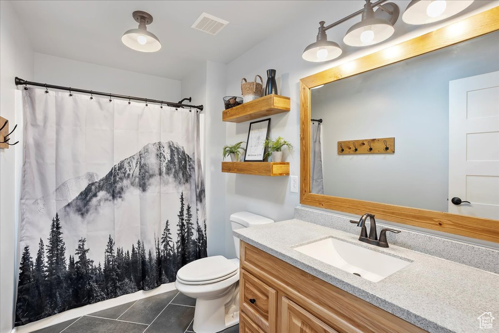 Bathroom featuring visible vents, toilet, tile patterned floors, vanity, and a shower with curtain