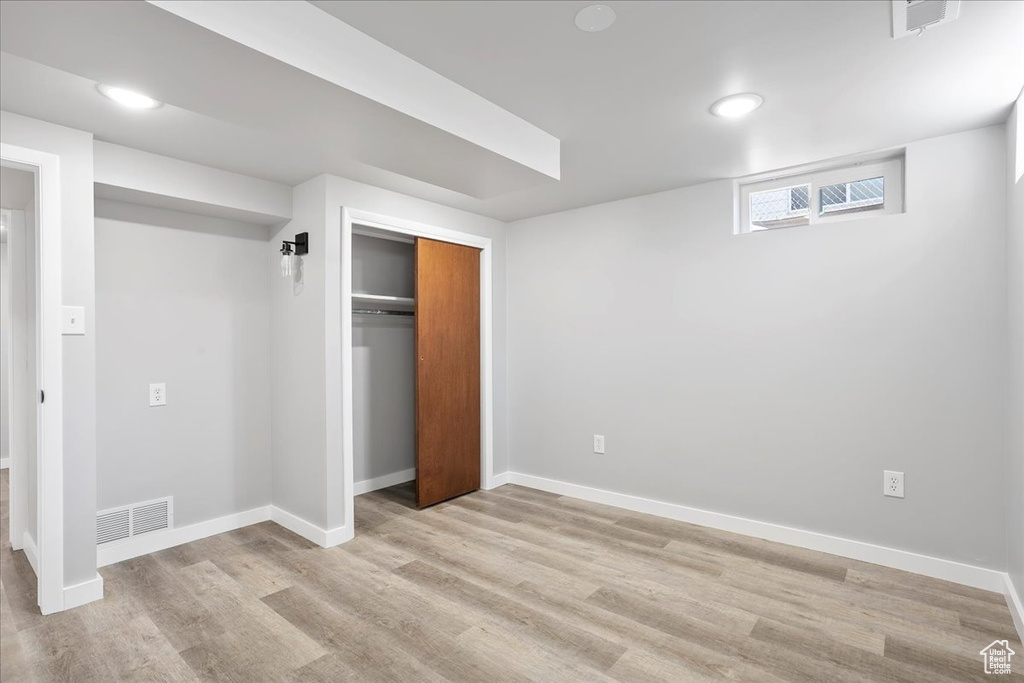 Unfurnished bedroom featuring baseboards, a closet, and light wood-style floors