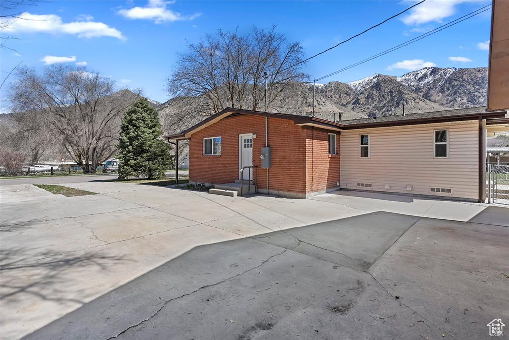 Rear view of property featuring brick siding and a mountain view