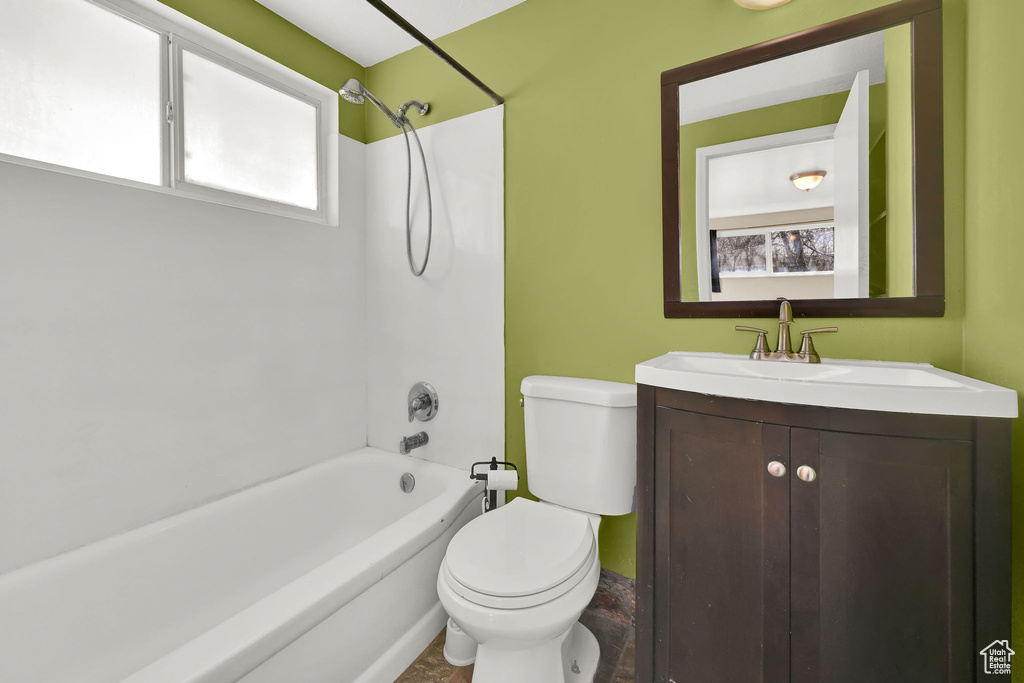 Bathroom with washtub / shower combination, toilet, and vanity