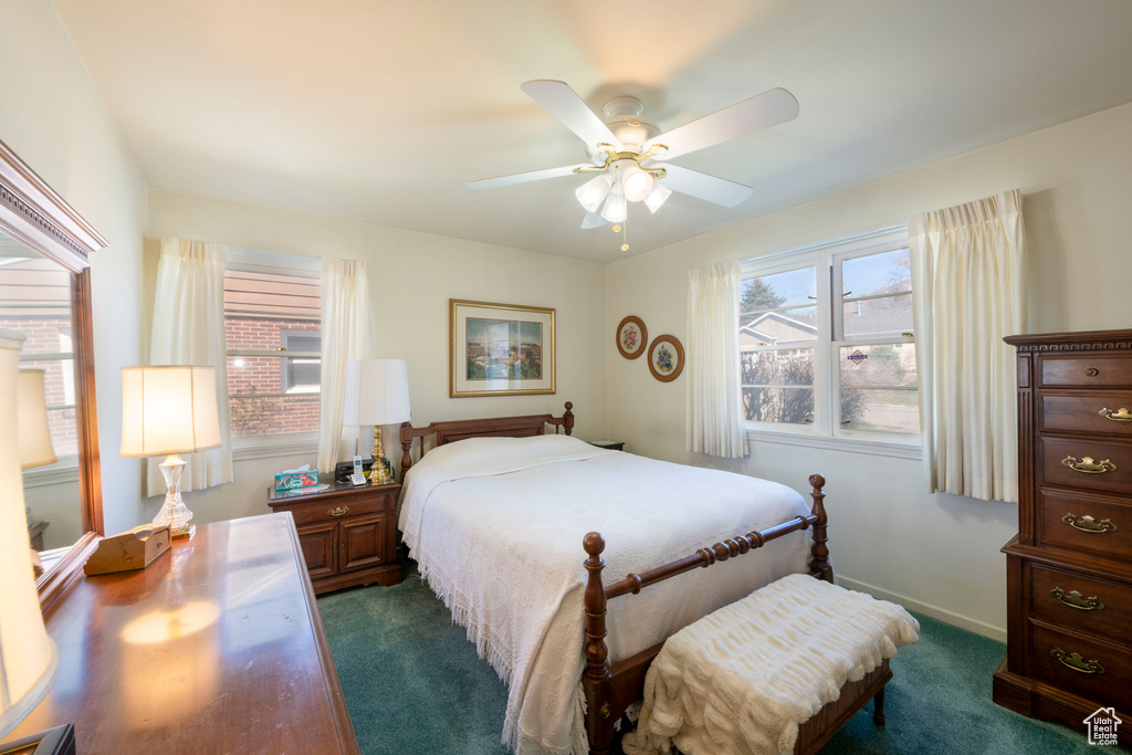 Bedroom featuring baseboards, dark carpet, and ceiling fan