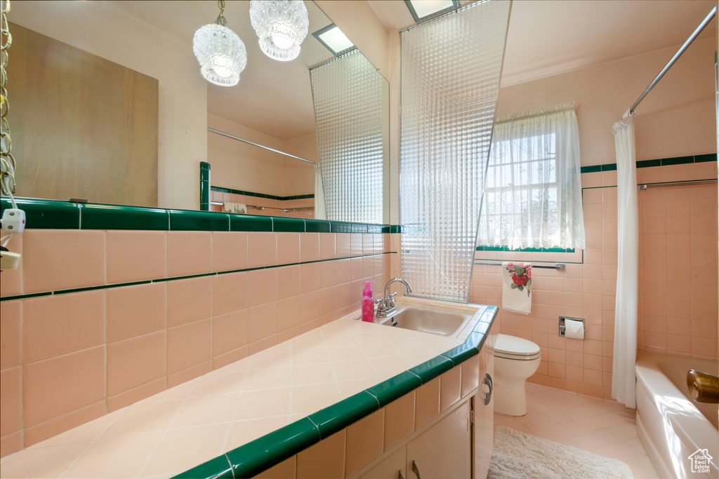 Bathroom featuring vanity, shower / tub combo, tile walls, toilet, and tile patterned floors
