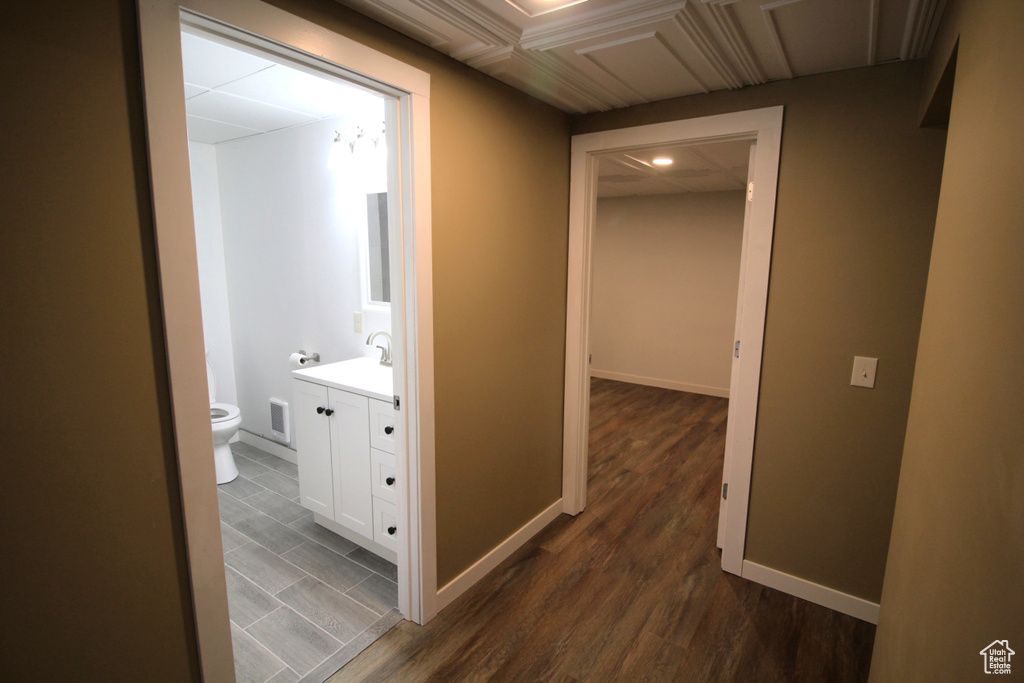 Hall featuring baseboards, visible vents, dark wood-style flooring, and recessed lighting