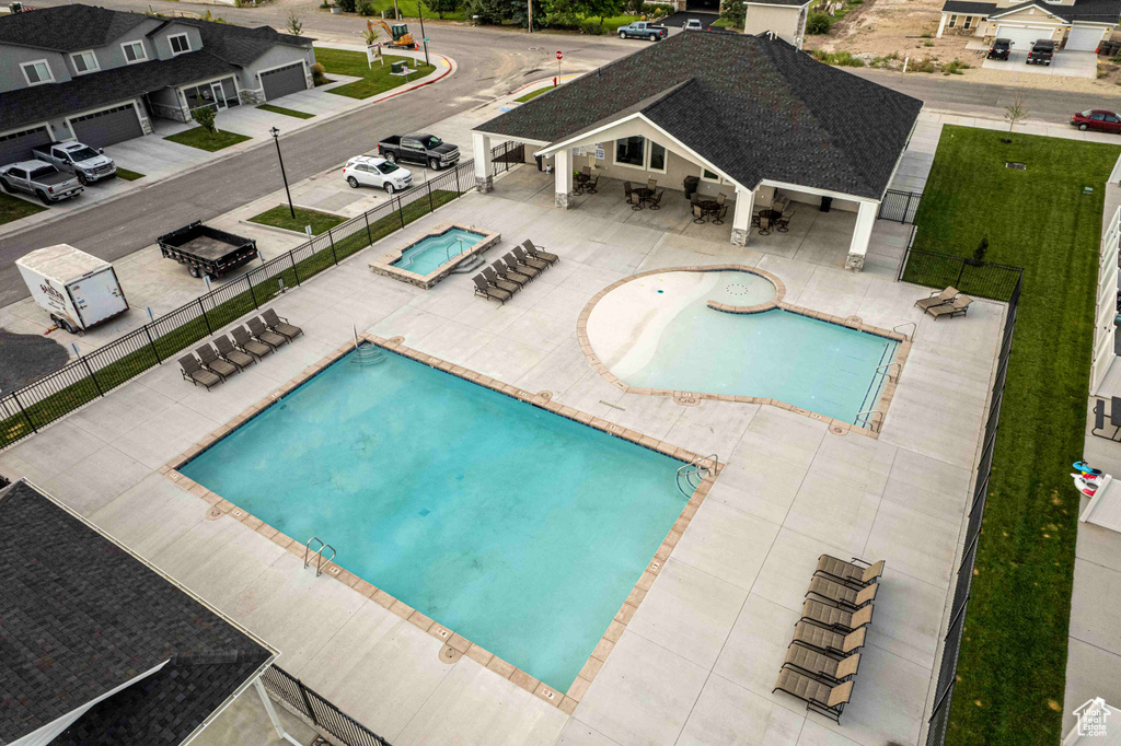 Pool with a hot tub, fence, and a patio area