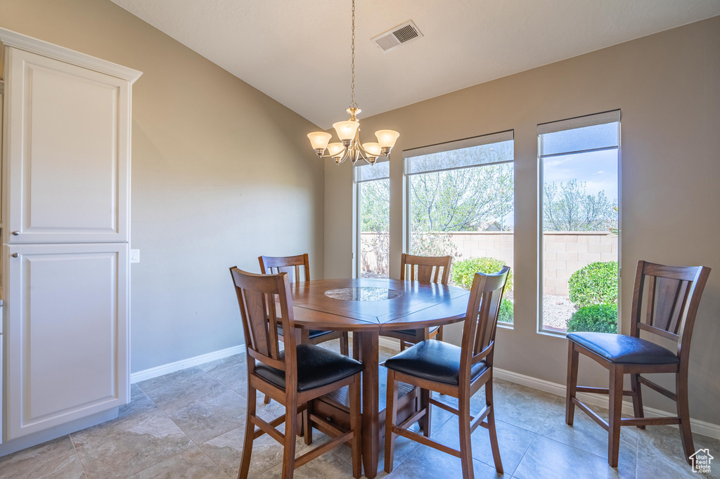 Dining room with baseboards, a notable chandelier, and visible vents
