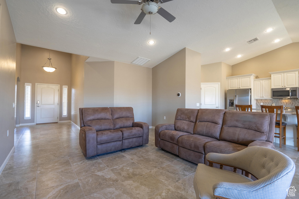 Living room featuring baseboards, visible vents, and a ceiling fan