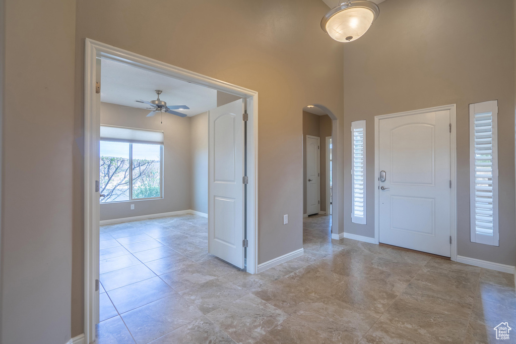 Foyer featuring arched walkways, baseboards, and ceiling fan