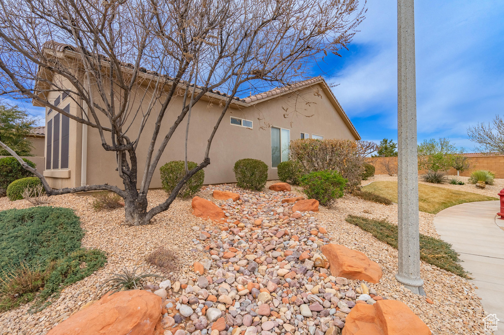 View of home\'s exterior featuring stucco siding, fence, and a tiled roof