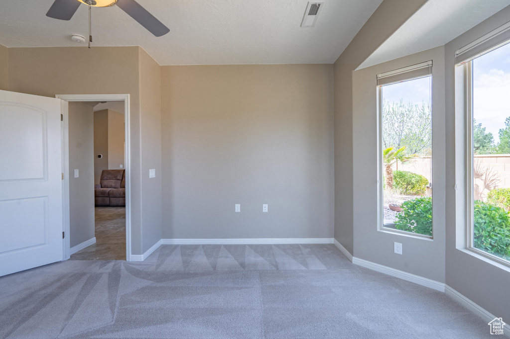 Empty room with baseboards, ceiling fan, and light colored carpet