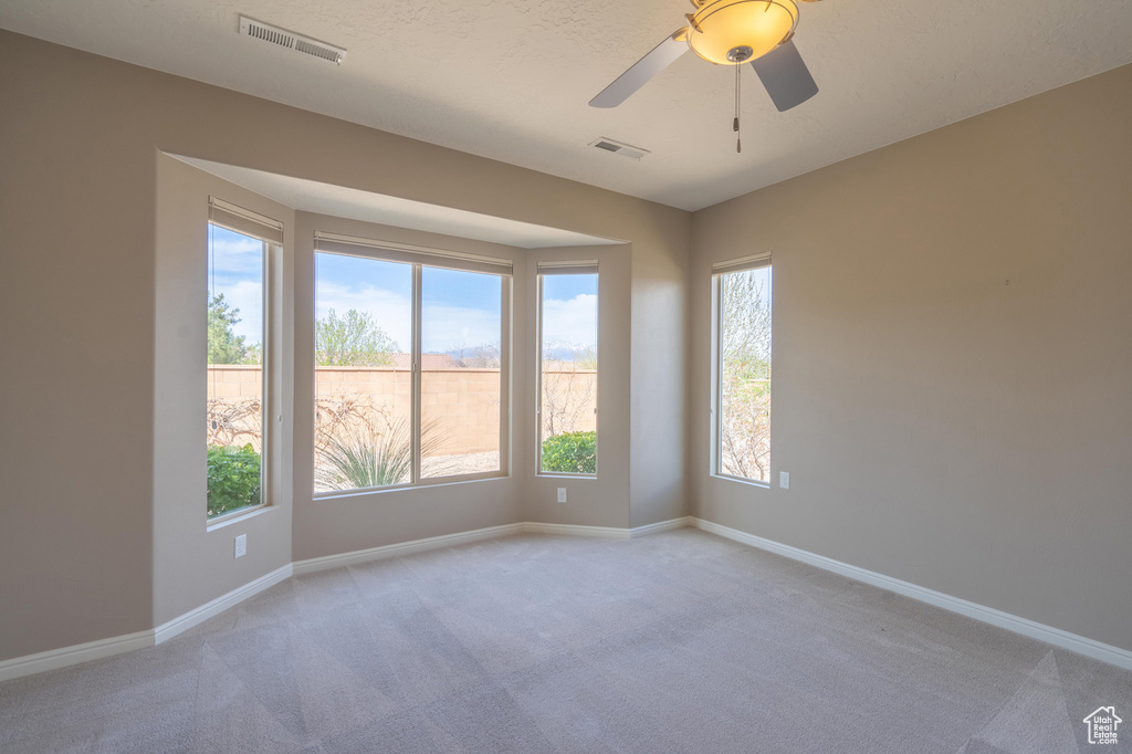 Spare room with light carpet, baseboards, and visible vents