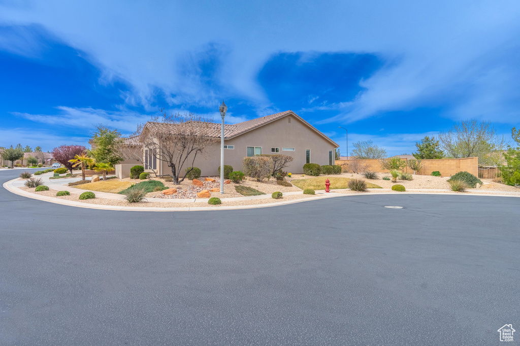 View of front of property with stucco siding and fence