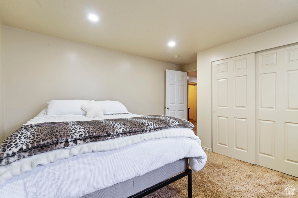 Carpeted bedroom with recessed lighting and a closet